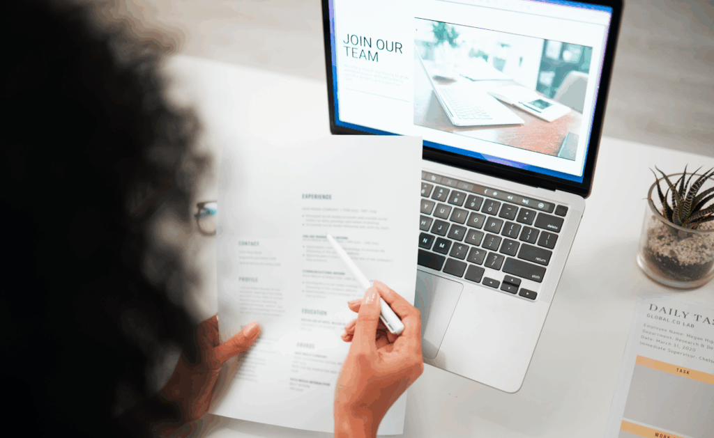Person writing a professional resume on laptop